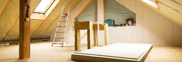 Unfertiger Dachboden mit Dämmung und Werkzeug